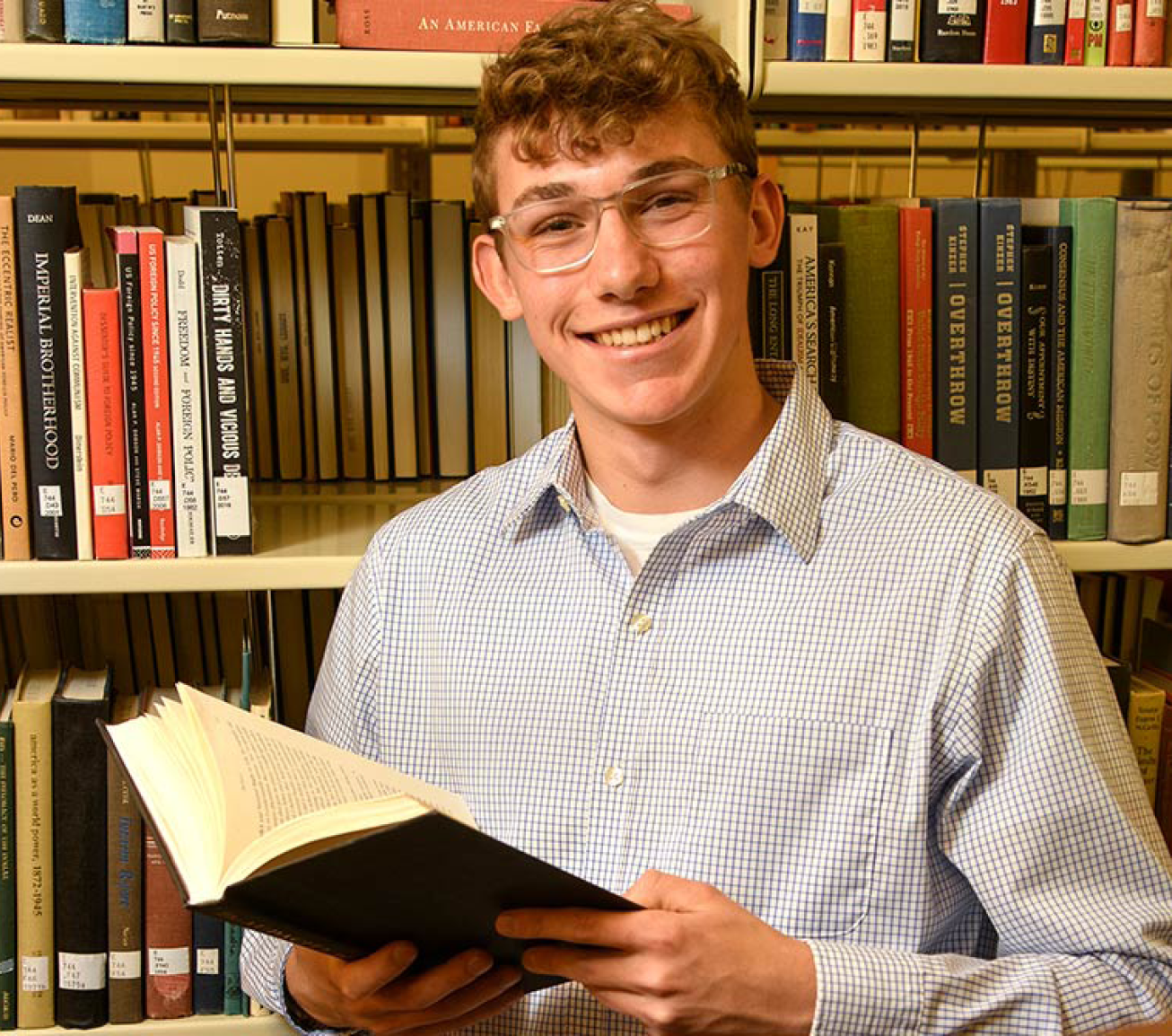 Student opening a book in the library