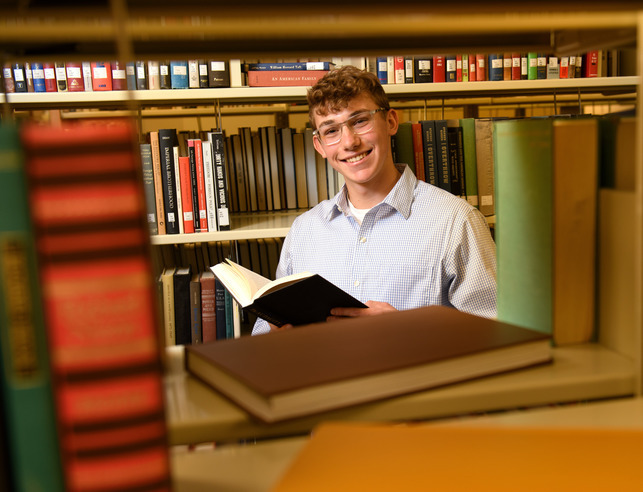 Student opening a book in the library