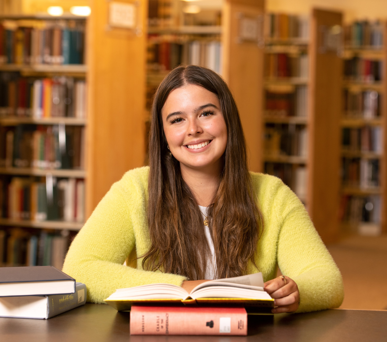 Student opening a book in the library