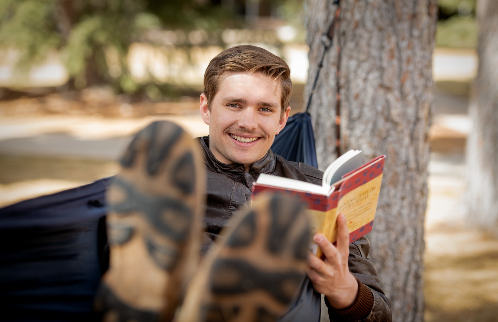 Student reading book in hammock