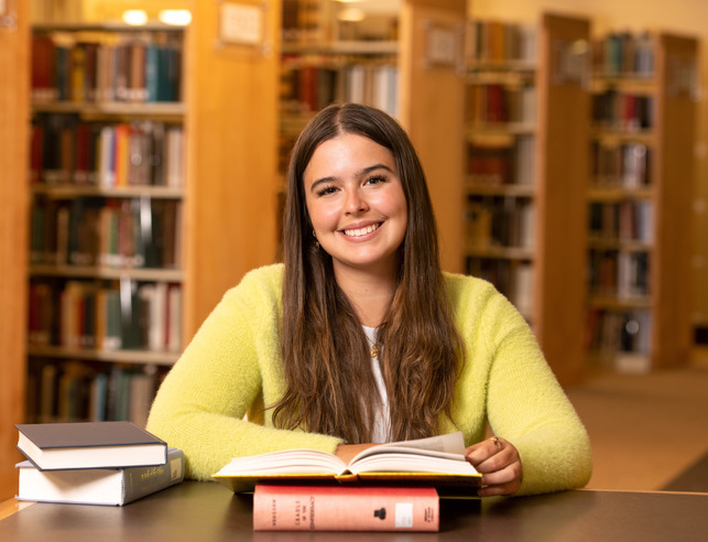 Student opening a book in the library