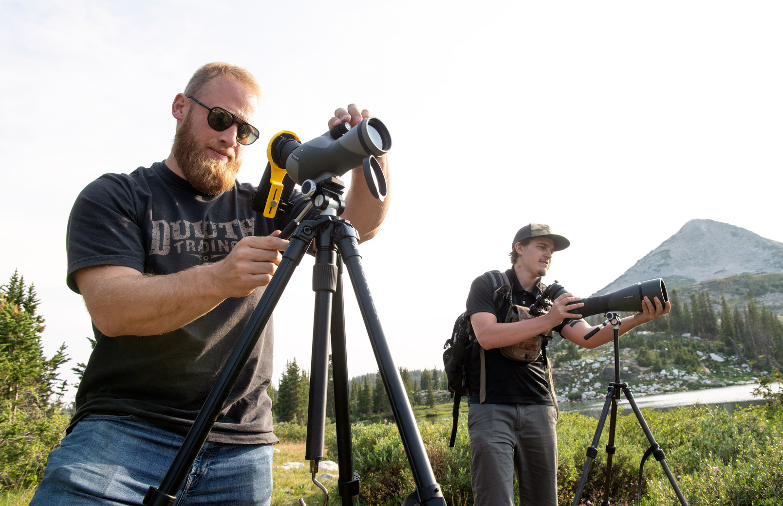 Two researchers looking through large cameras