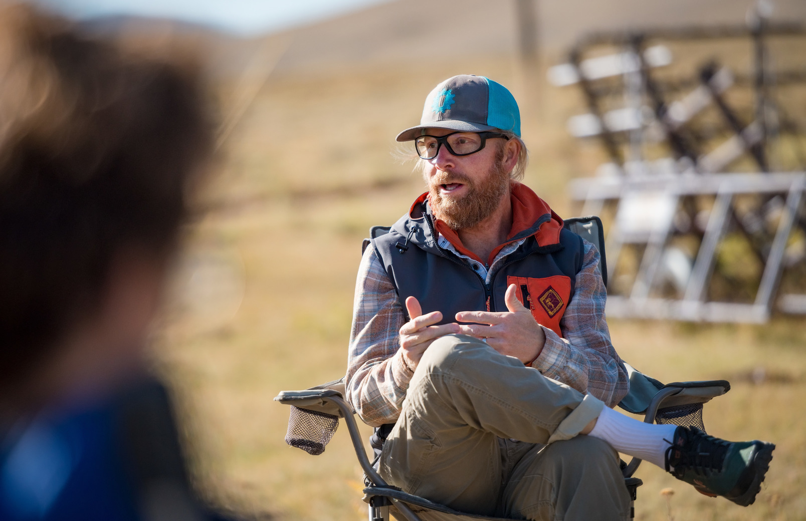 A professor talks to a group of people in a lawn chair