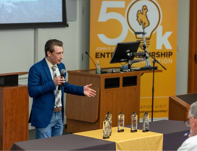 An entrepreneurship student speaking into a microphone