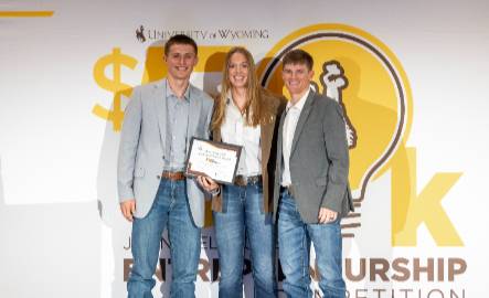 Three entrepreneurship students smile at the camera