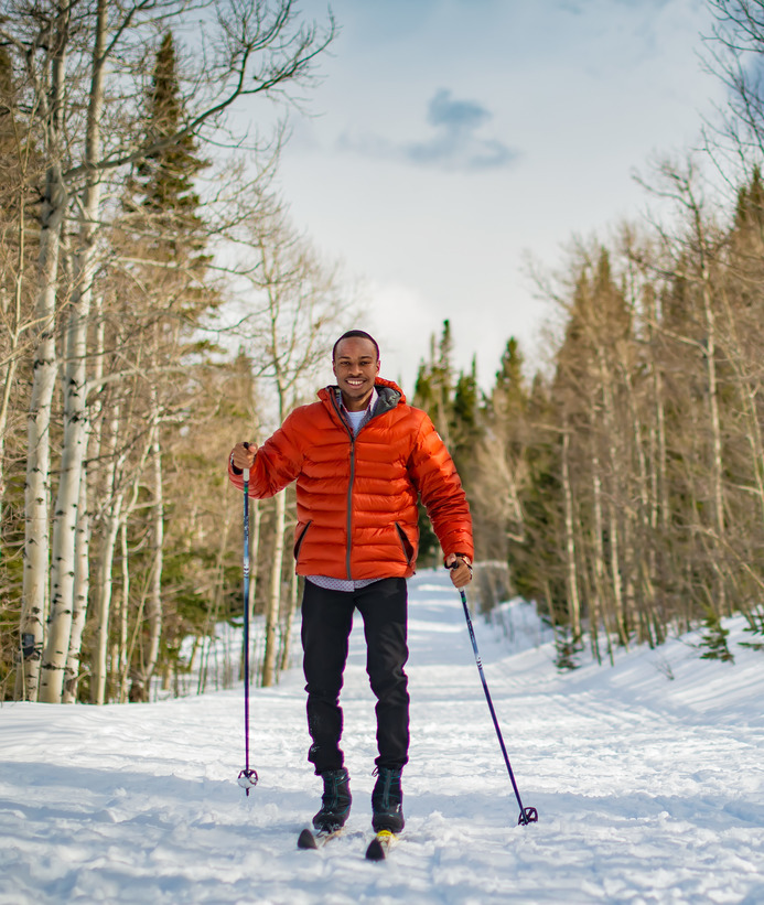 A student smiles for a photo while cross country skiing