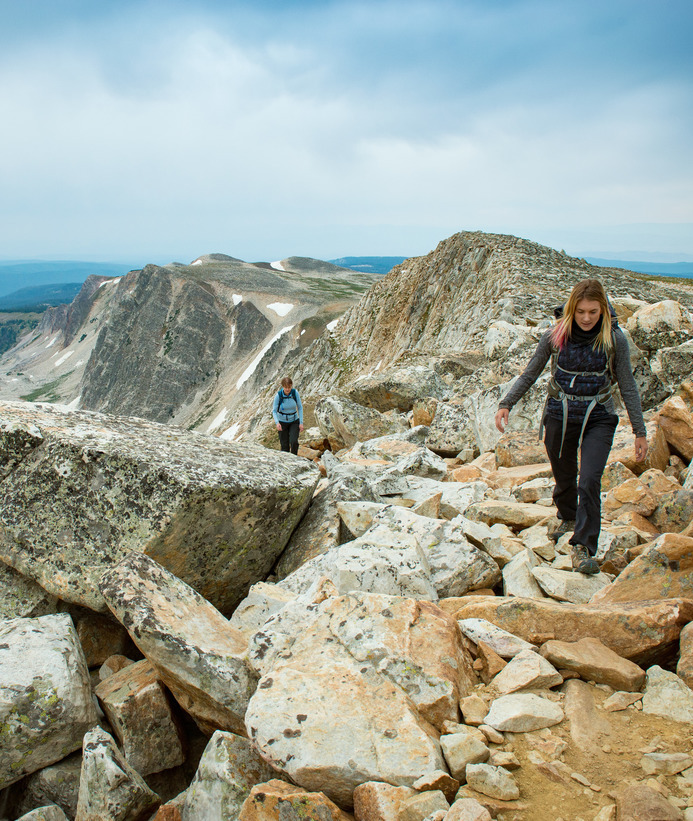 Students walking on a trail with mountains in the background