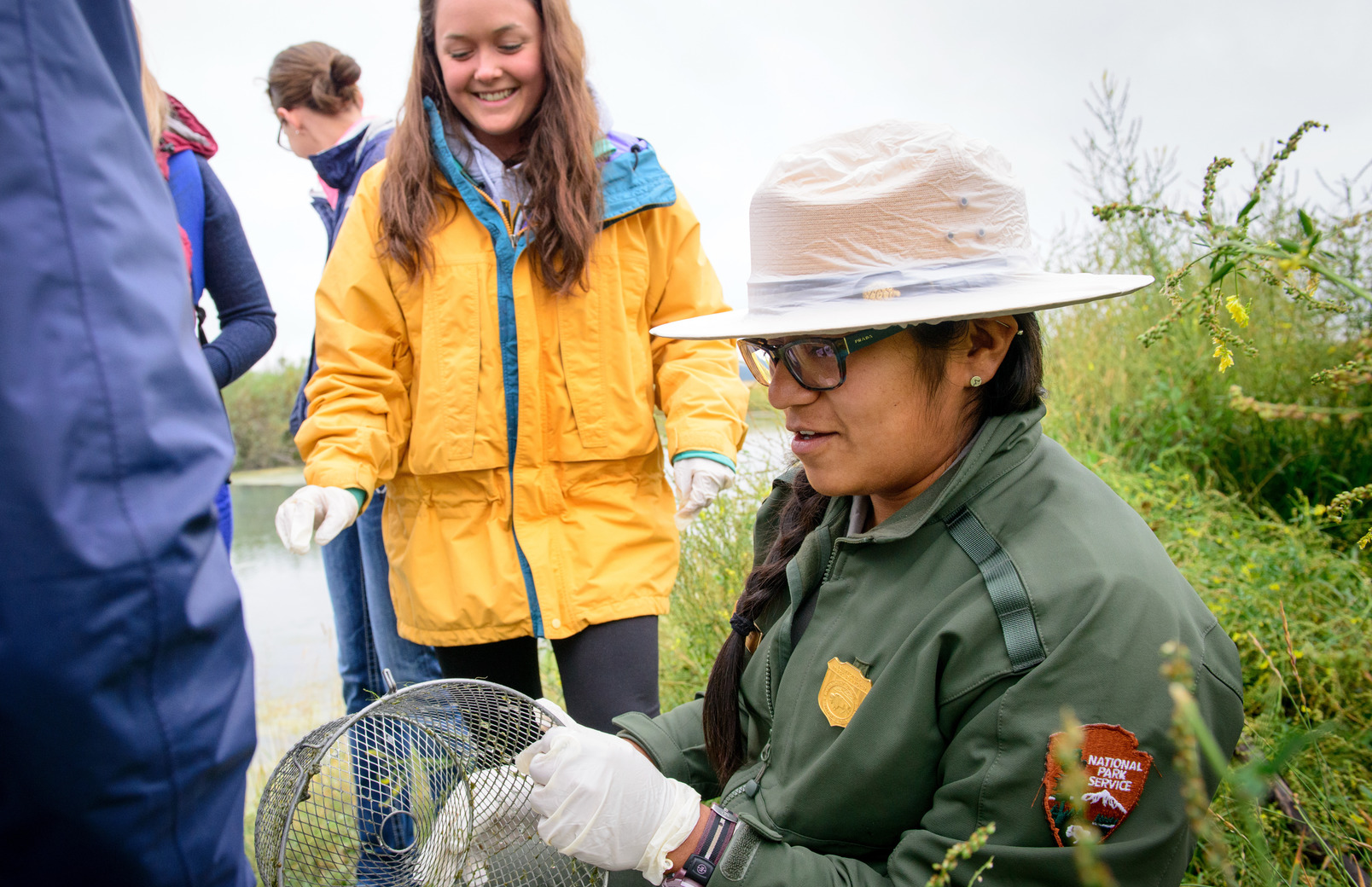 A national park services employee talks to a class out in the field