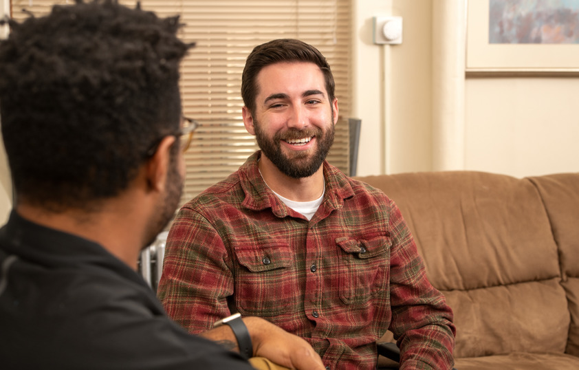 Two people talk and smile at each other