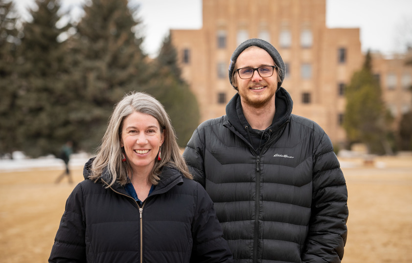 Two faculty members smile for a photo