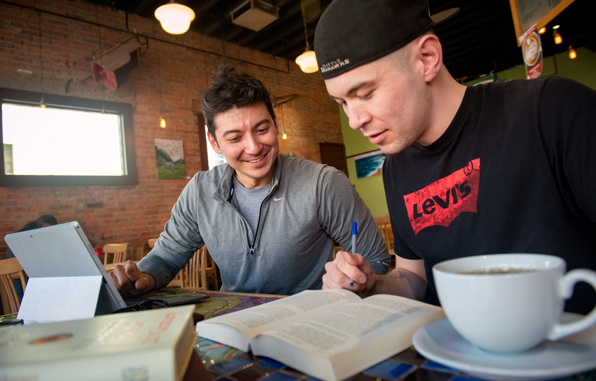 Two students working on classwork at a coffee shop