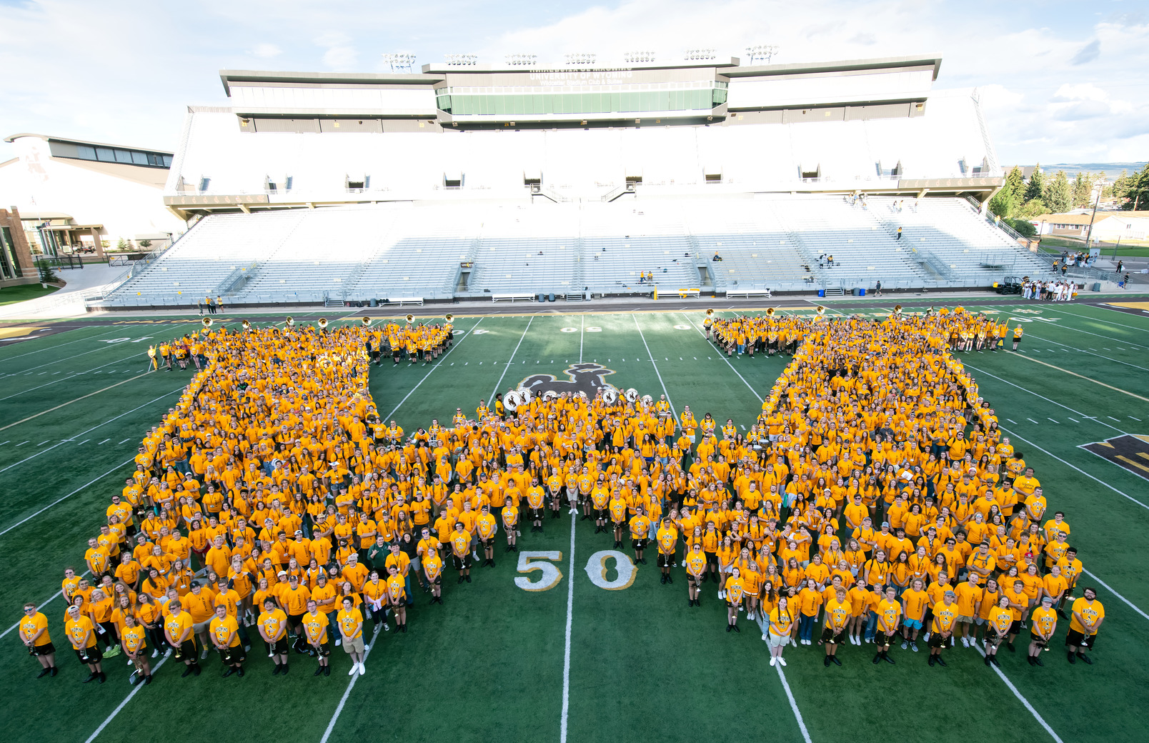 Students making a "W" on the football field for class picture