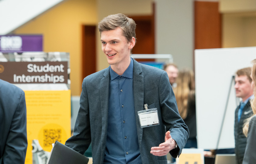 A student speaks to potential employers at a career fair on campus.