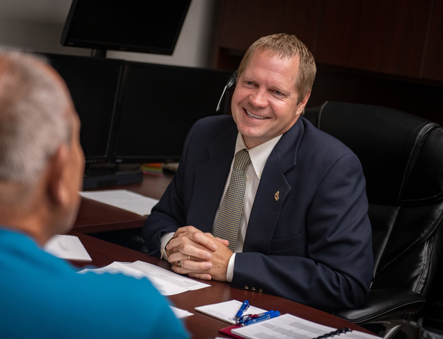 Banker sitting at a desk talking to a client