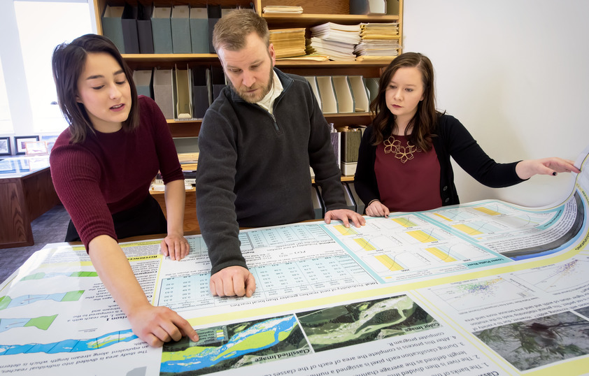 Students and professor looking at maps