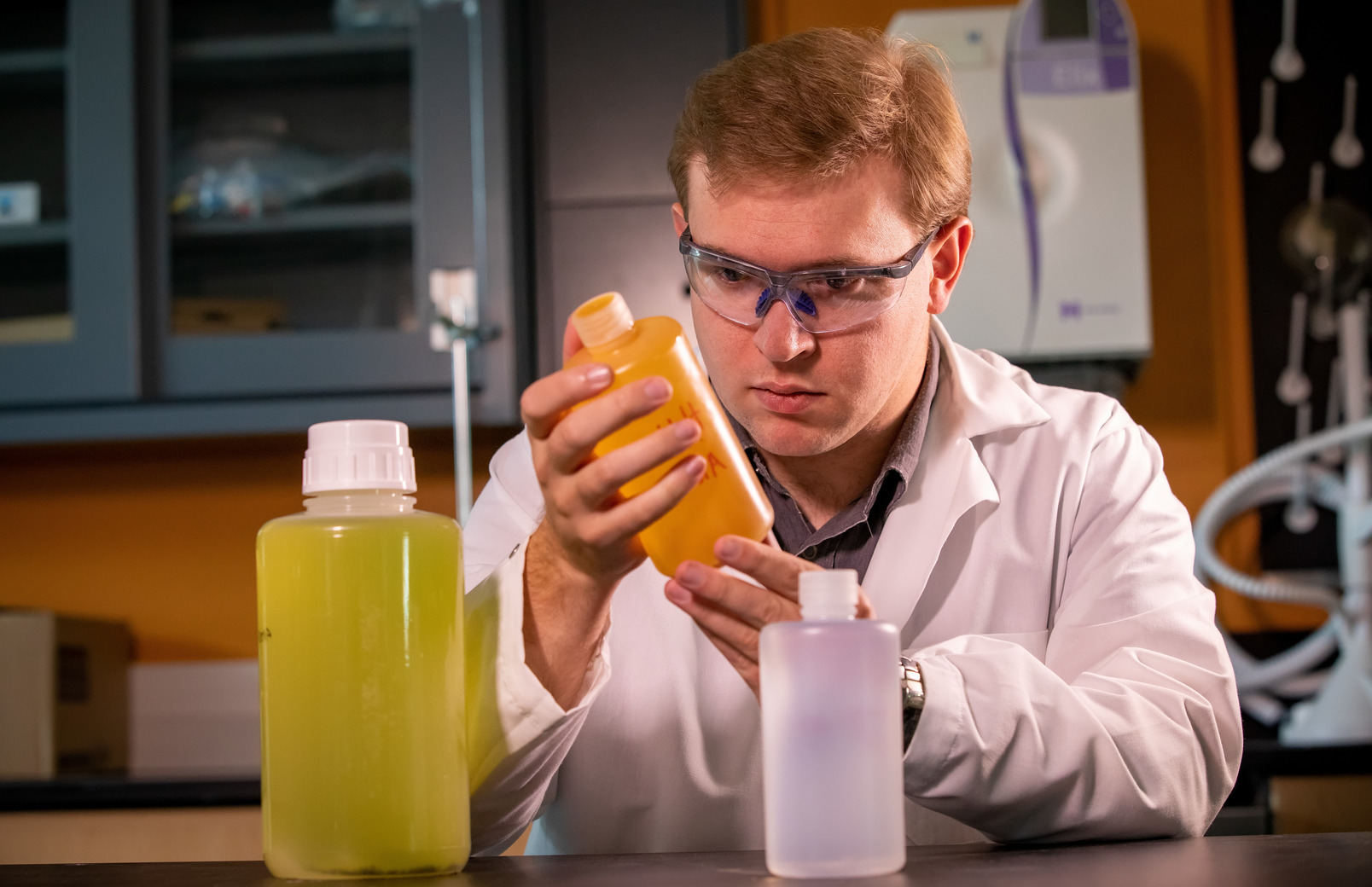 A student looks at two containers full of liquid in a lab