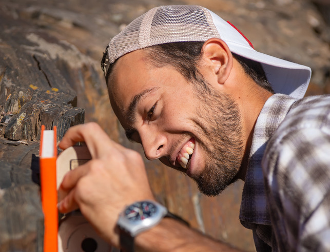 A geology student takes measurements in the field