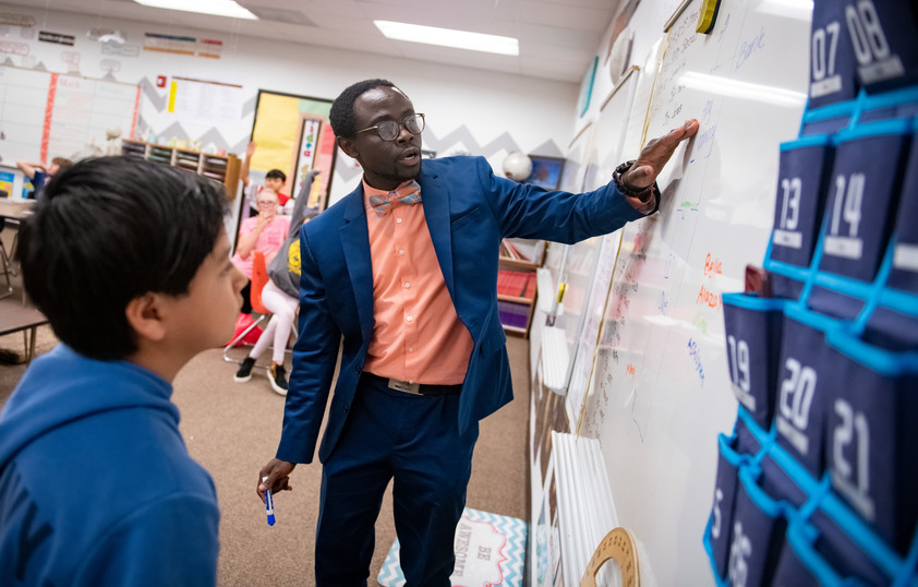 Teacher teaching student at white board