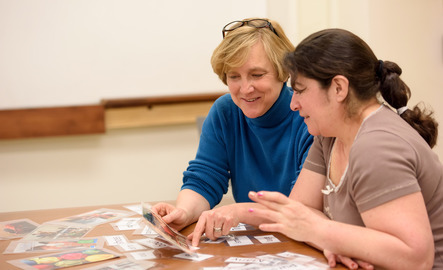 Faculty and student using flashcards to work on language