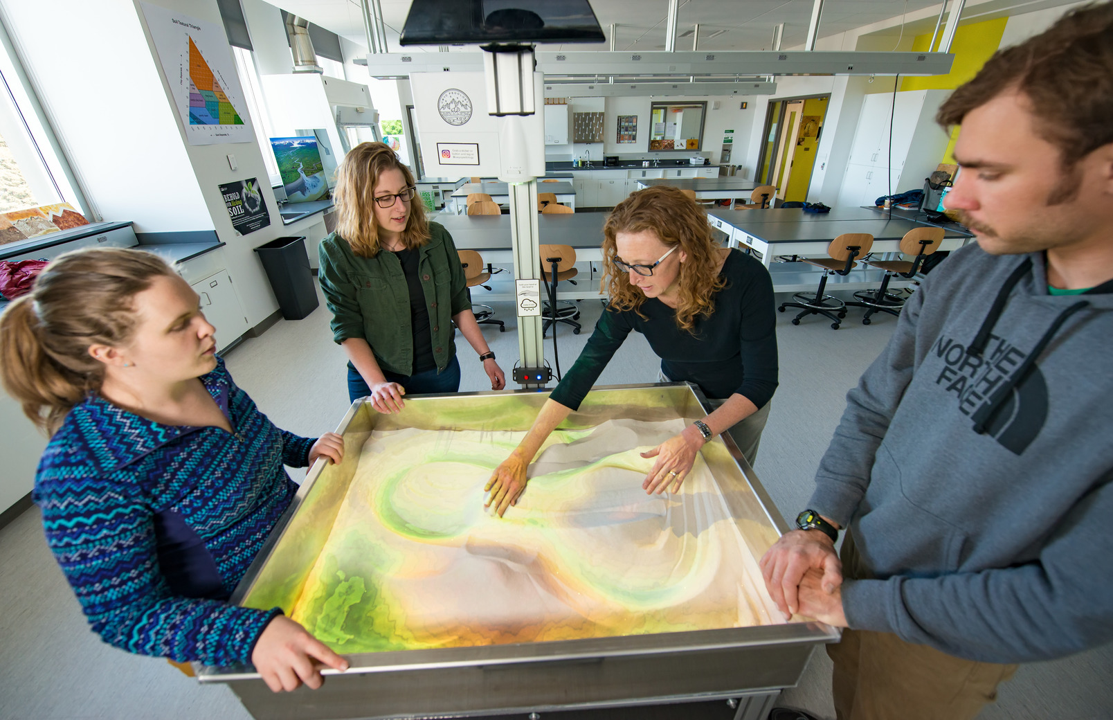 Students work together in a lab looking at a 3D map
