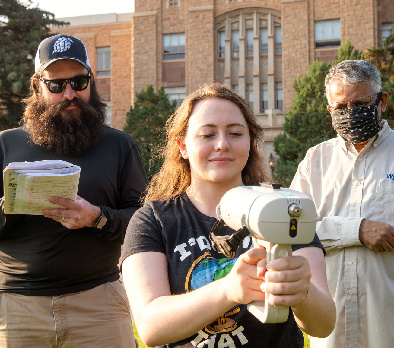 Two students in lab with a professor