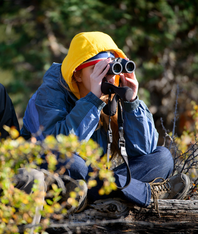 A student looks out a set of binoculars