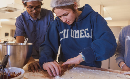 Two students work together in class to make food