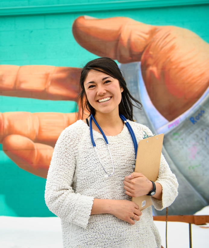 Healthcare professional posing in front of a mural in downtown Laramie