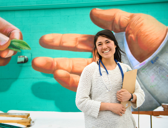 Healthcare professional posing in front of a mural in downtown Laramie