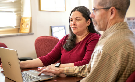 UW faculty members working on a laptop together