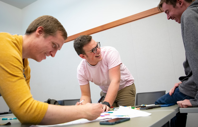 Three students work together in class