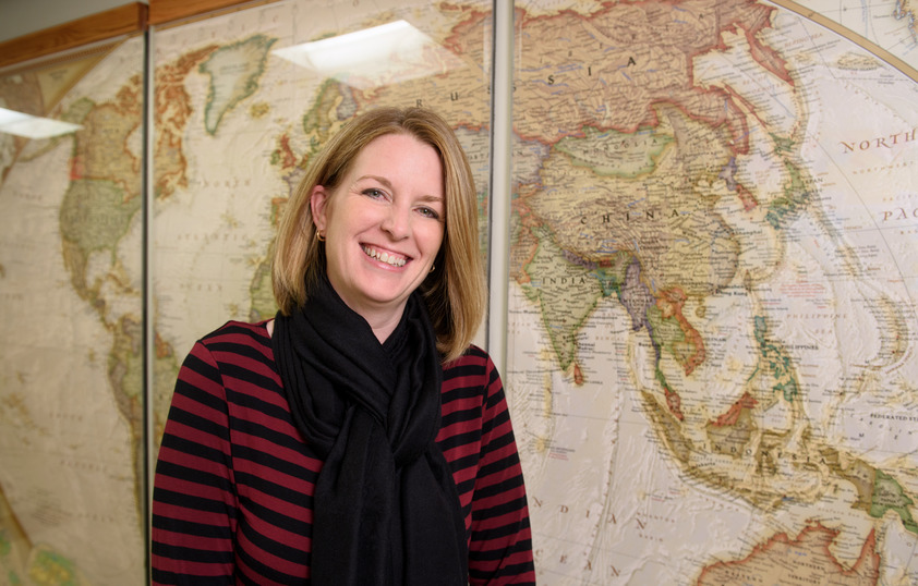Staff member posing in front of map