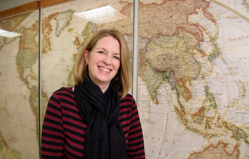 Staff member posing in front of map