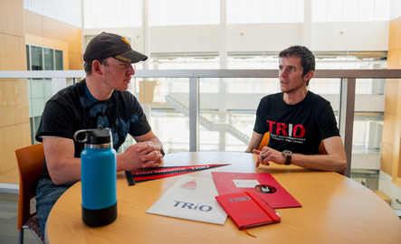 Two people sit and talk at a table