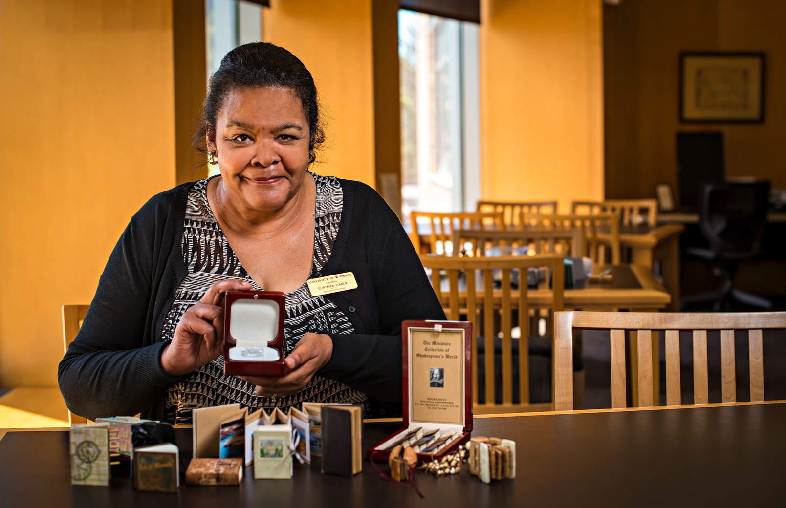 Librarian posing for picture with a Native American tiny book collection