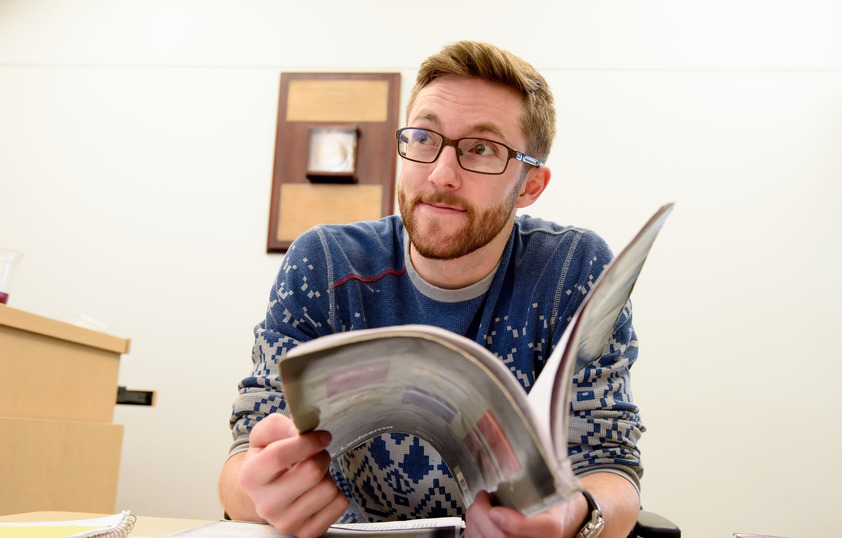 Student listening in class while opening a book