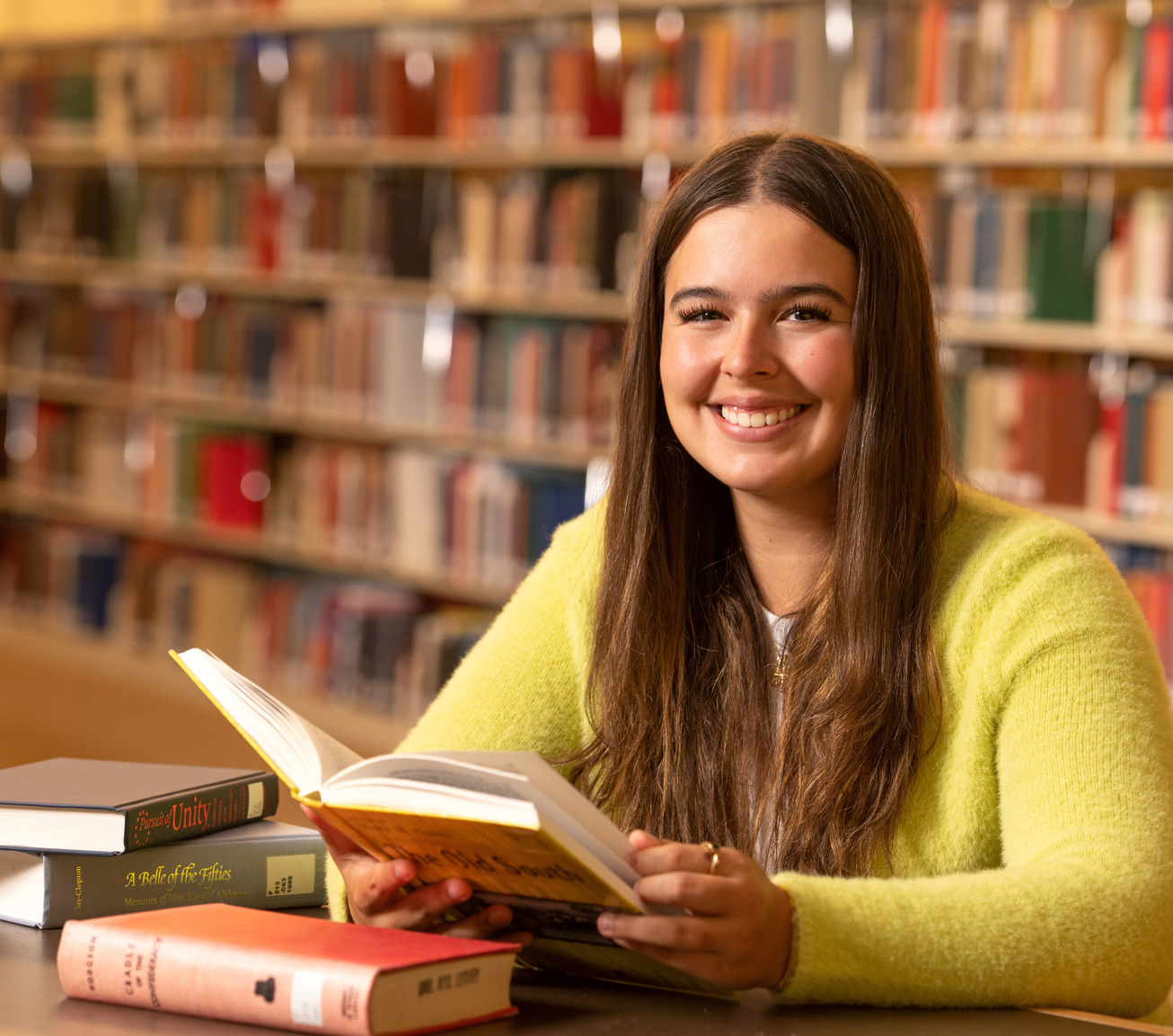 Student opening a book in the library