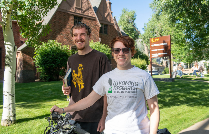 Two students smiling outside of the Guthrie house on UW's campus