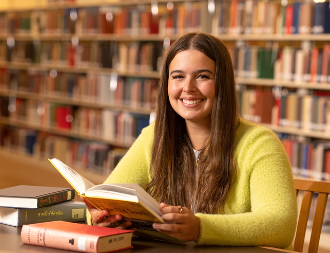 Student opening a book in the library