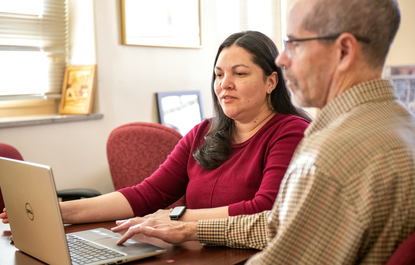 Two people working on a laptop together