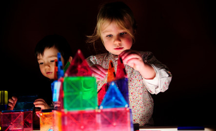 Young child playing with light-up blocks