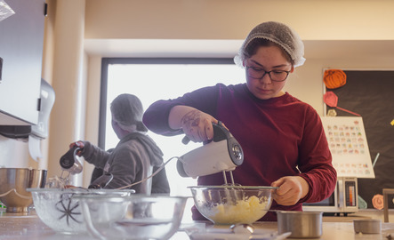 Student using a food mixer in a human nutrition class