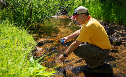 Faculty member recording data from body of water