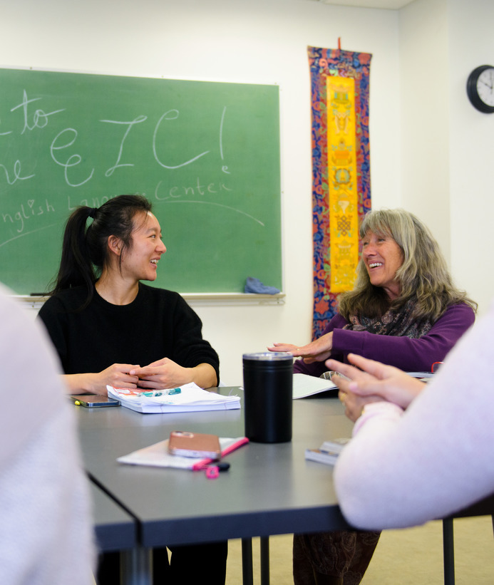 A student and teacher talk during class in the English Language Center