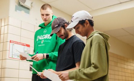 Three students examine a piece of paper each during an class activity