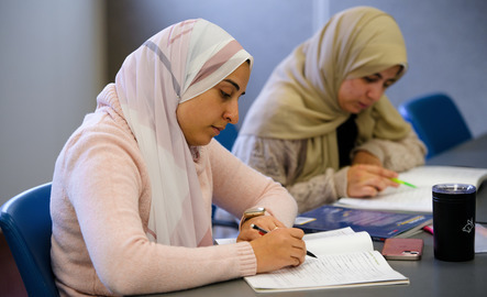 Two students work on paperwork during class