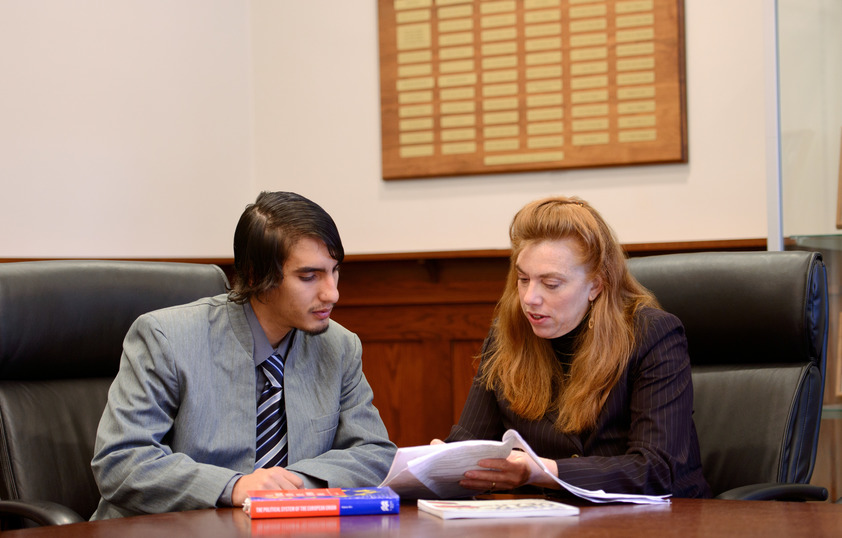 Professor looking through files with student