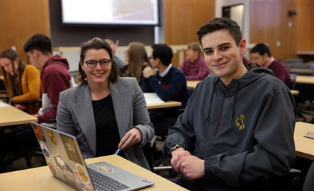 Two students smile for the camera