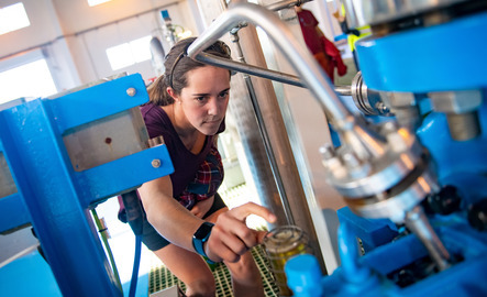 Student examining a piece of machinerary during a study abroad trip