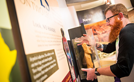 A student hangs up a shadow box in a museum